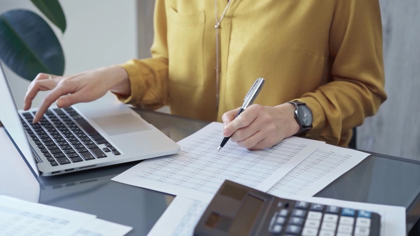 Personalized Financial Planning Solutions Stoic Wealth Advisors Professional reviewing budgeting and financial planning documents beside a laptop and calculator