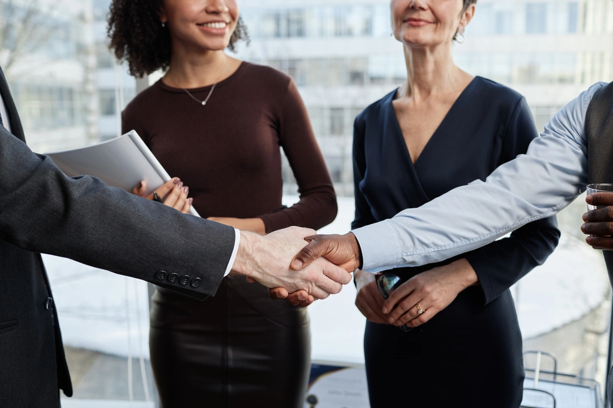 Trusted Financial Partnerships Stoic Wealth Advisors Business professionals shaking hands during a financial planning and client relationship meeting