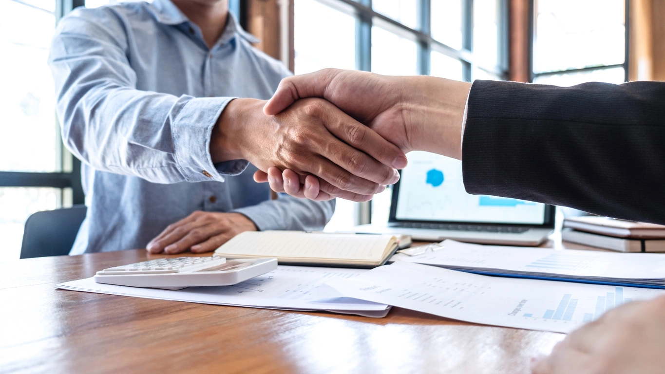 Trusted Financial Planning Partnerships Stoic Wealth Advisors Business professionals shaking hands during a financial planning and wealth management consultation